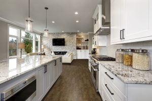 Beautiful modern kitchen in luxury home interior with large island and stainless steel appliances.