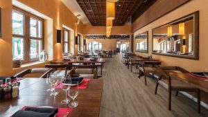 Cafe restaurant interior with wooden furniture lighting equipment and decoration.